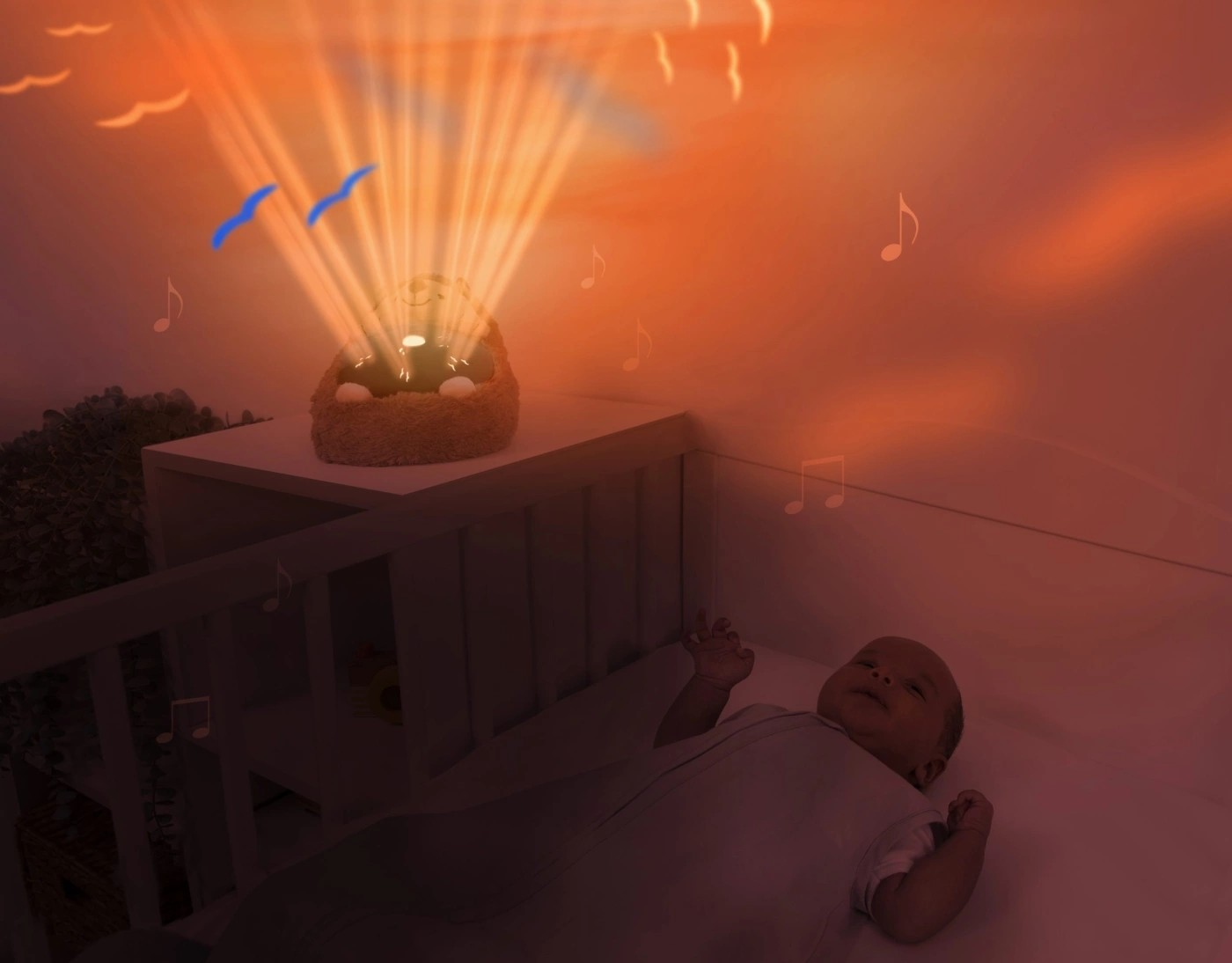 Luz projetada com notas musicais e pássaros azuis numa parede laranja próxima de berço com bebé