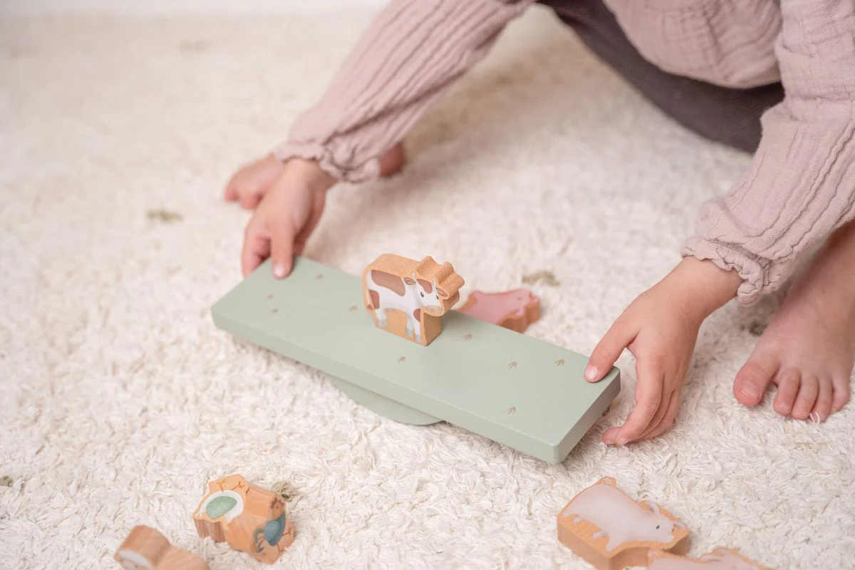 Brinquedo de balança infantil em madeira verde com animais de madeira