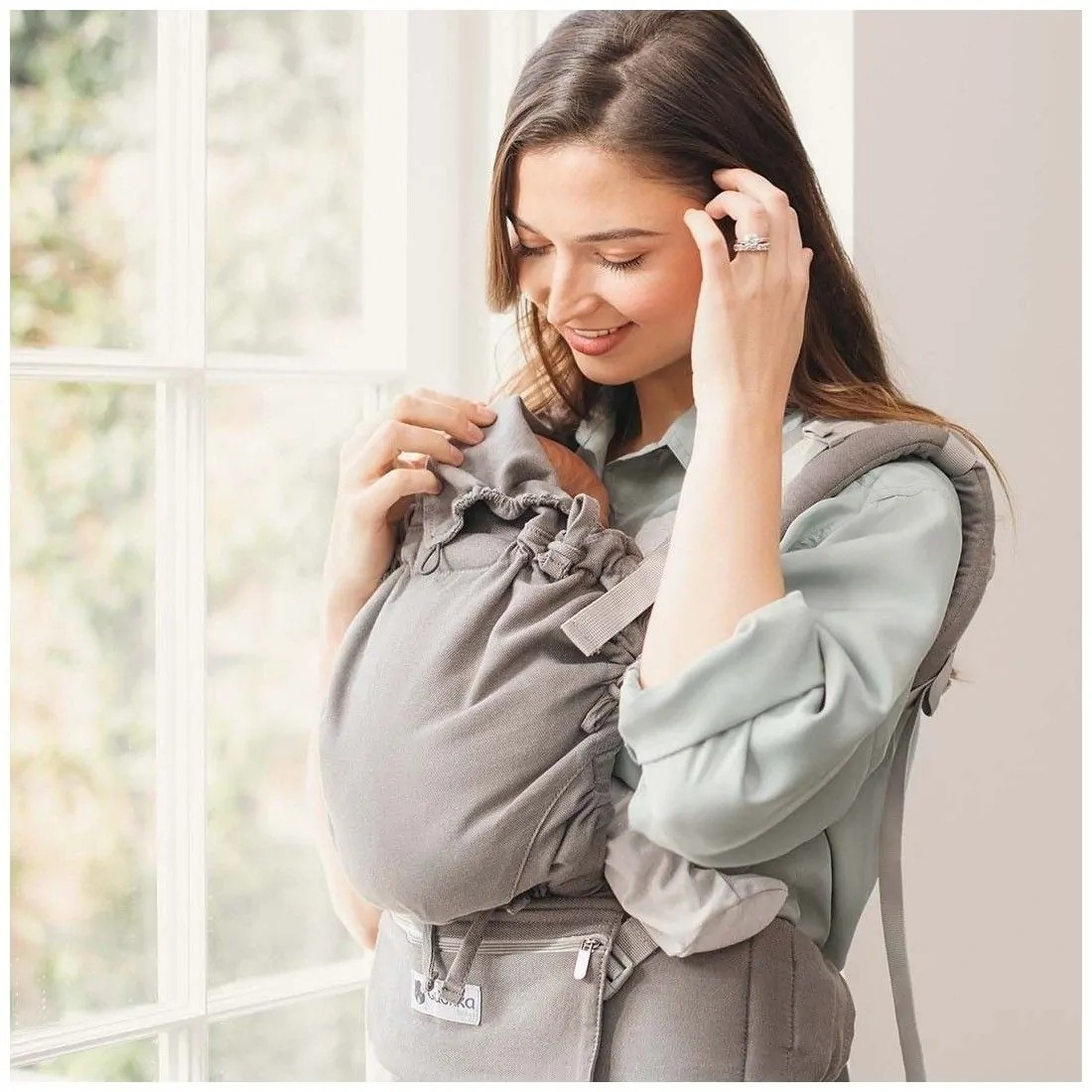 Mulher a usar canguru para bebé cinza claro com bolso e cordão ajustável