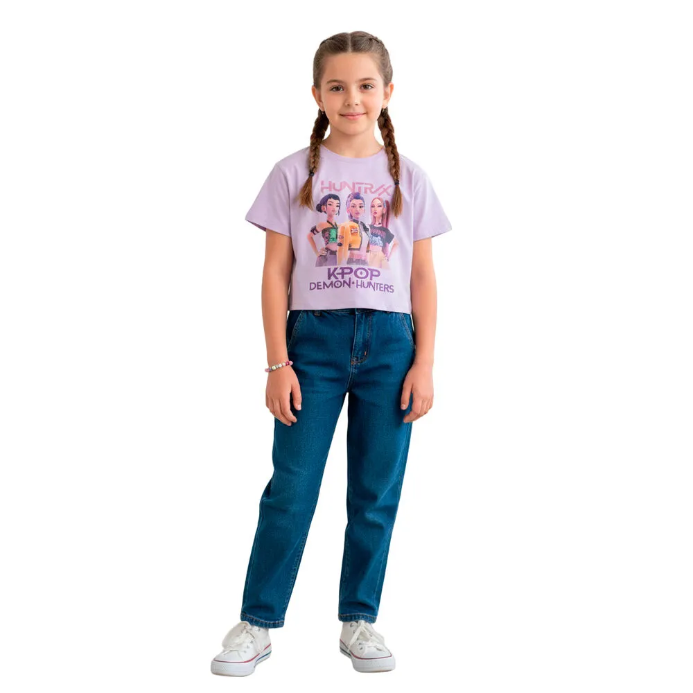 Rapaz com t-shirt lilás estampada e calças de ganga azuis em fundo branco