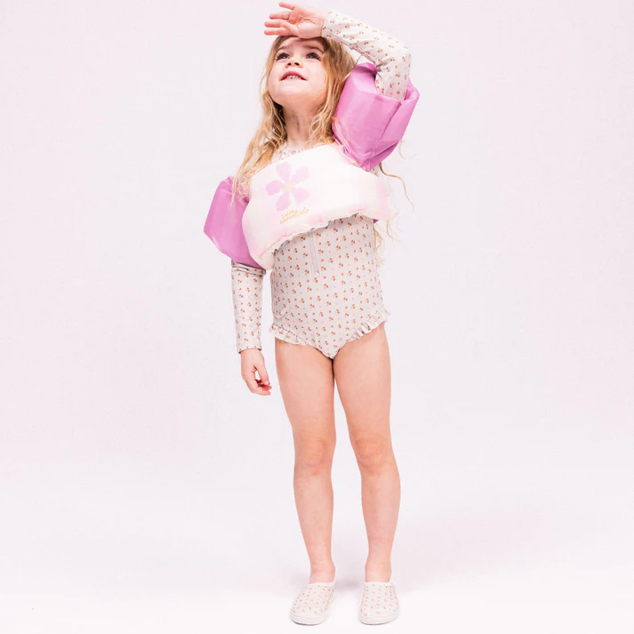 Menina com equipamento de flutuação e fato de banho com padrão floral