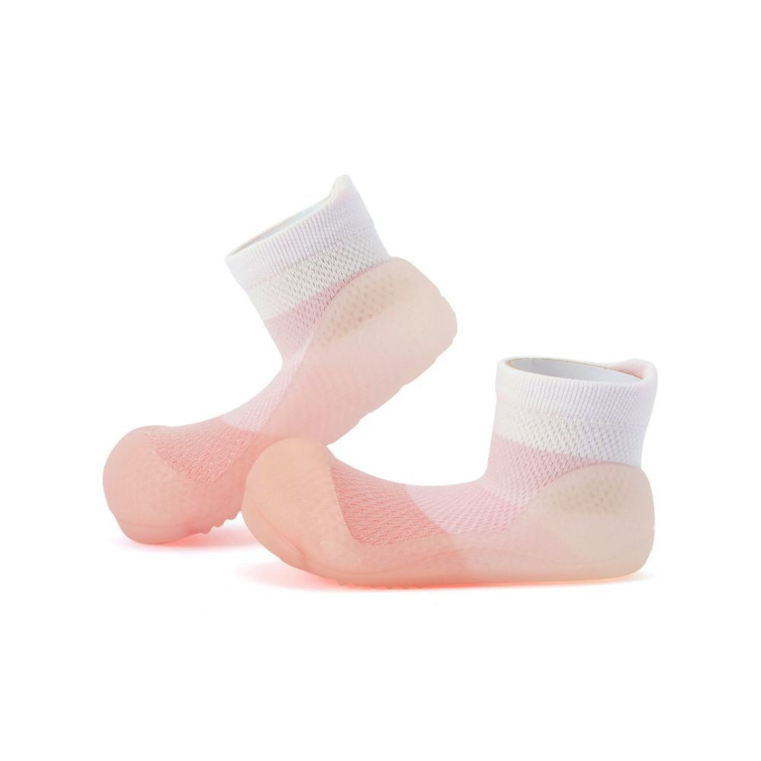 Meias tipo sapatilha para bebé em rosa e branco com sola antiderrapante.