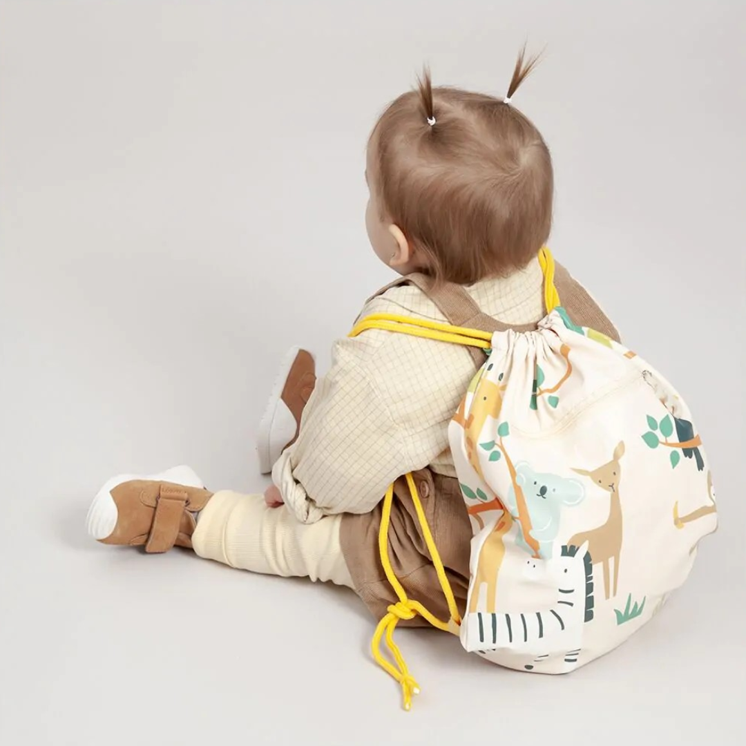 Criança sentada com mochila saco estampada de animais
