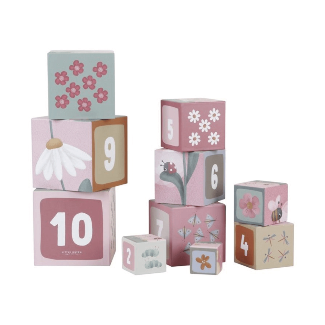 Blocos de empilhar infantis com números e desenhos de insetos e flores em tons rosa e bege.