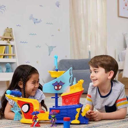 Crianças brincam com barco de brinquedo colorido em sala decorada