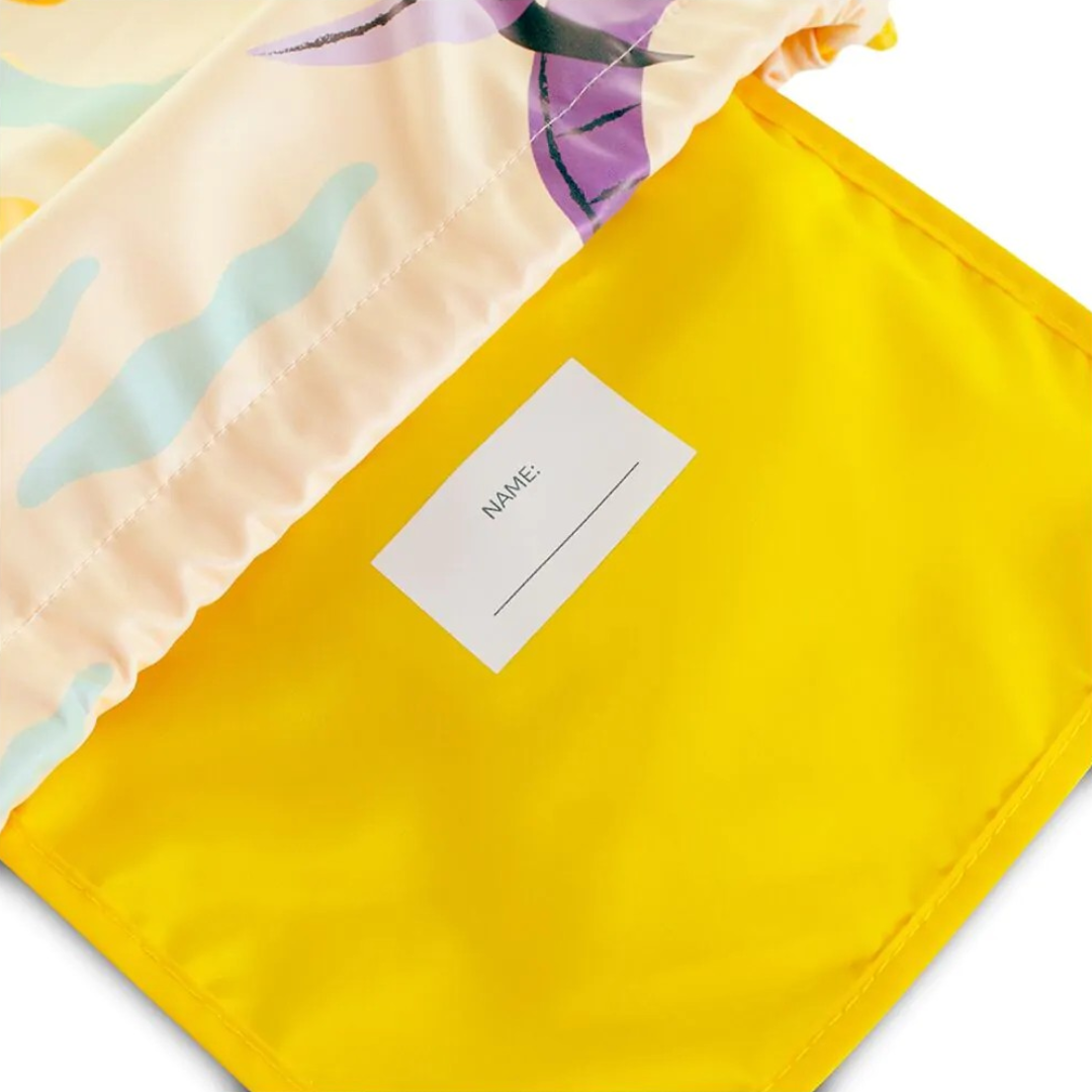 Detalhe de saco escolar com interior amarelo e etiqueta para nome