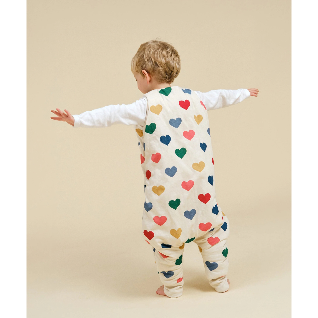 Criança com saco de dormir estampado de corações