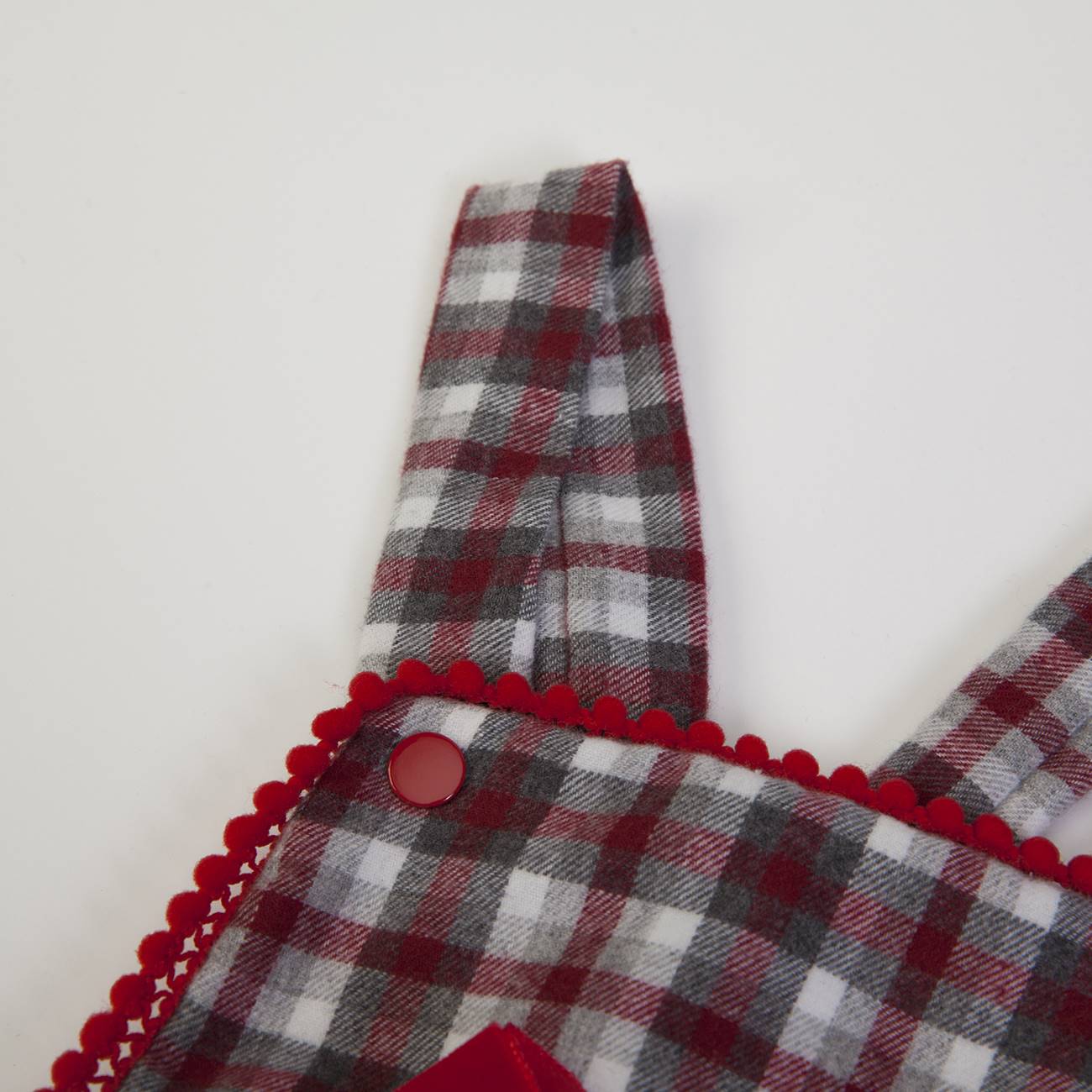Peça de roupa xadrez vermelha, cinza e branca com botões e renda vermelha
