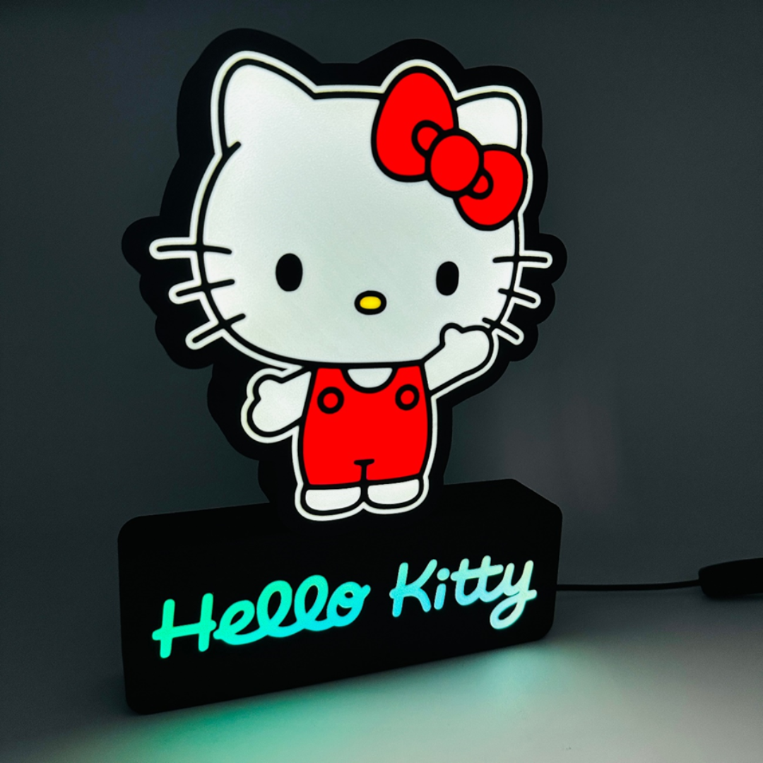 Luminária da Hello Kitty branca e vermelha com base preta iluminada onde está escrito 'Hello Kitty' em azul