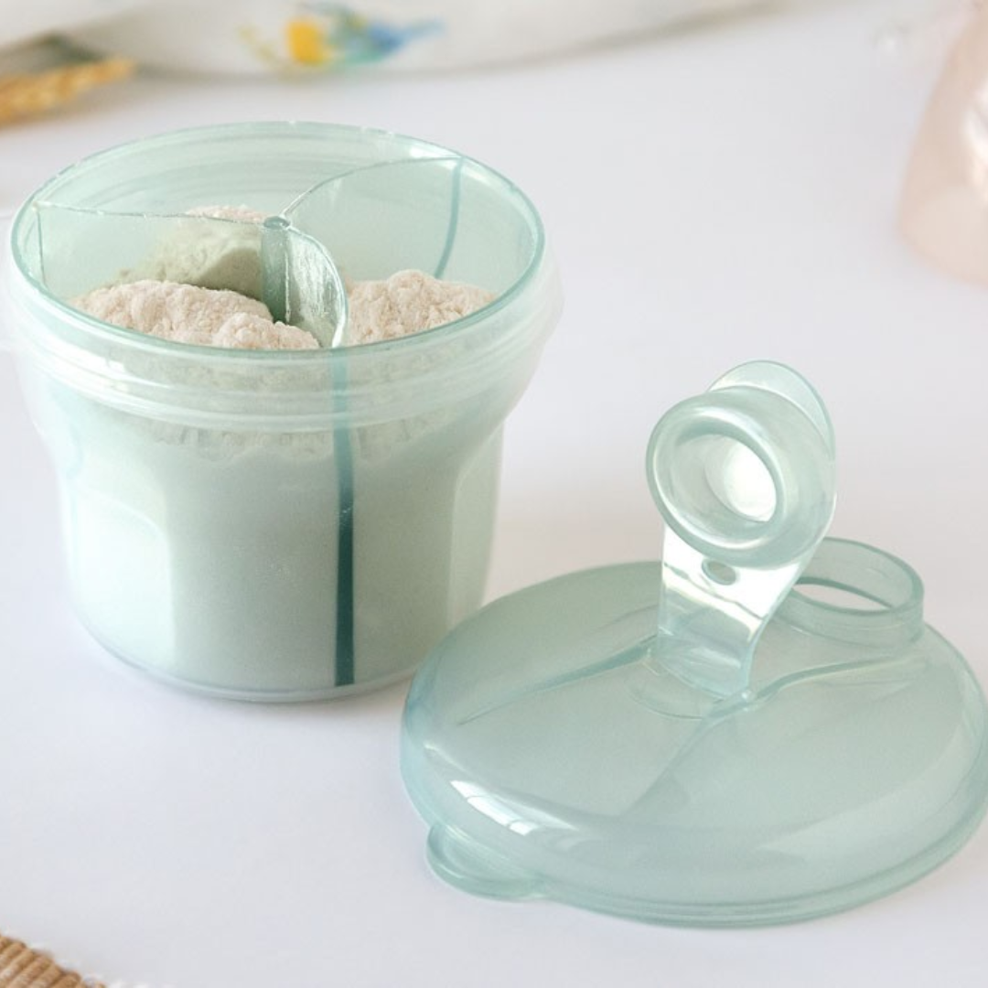 Recipiente plástico com três divisórias contendo diferentes pós claros e tampa destacada sobre superfície branca