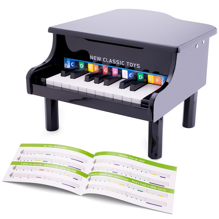 Piano infantil preto brilhante com blocos coloridos nas teclas e livro de partituras aberto