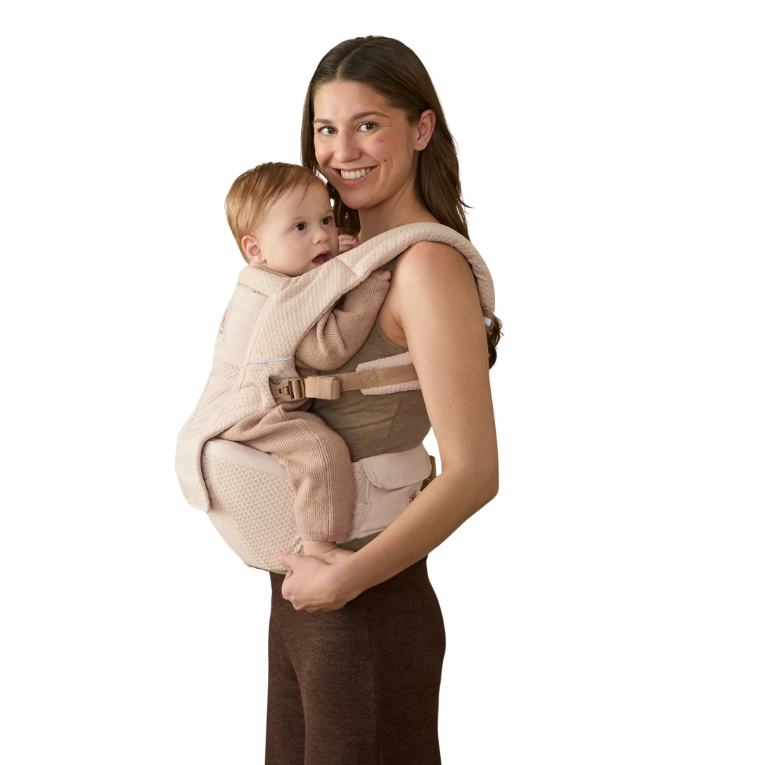 Mochila porta-bebés bege claro com fechos usada por mulher sorridente com um bebé