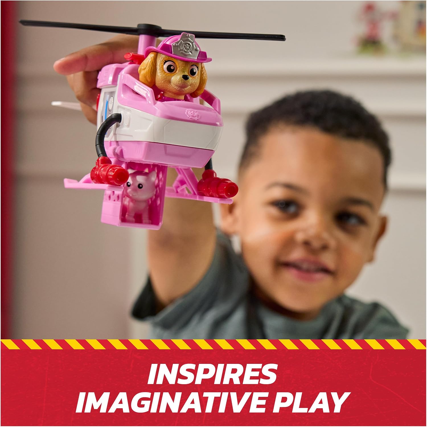 Brinquedo de helicóptero rosa com cão bombeiro segurado por criança