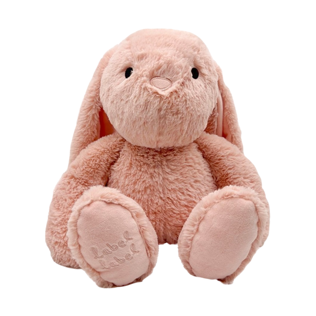 Ursinho de peluche rosa claro com olhos pretos e texto bordado nos pés