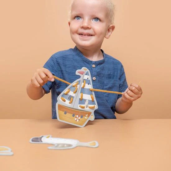 Criança com brinquedo de madeira em forma de barco a passar corda.