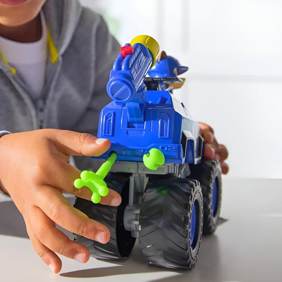 Brinquedo de veículo azul com detalhes coloridos nas mãos de criança