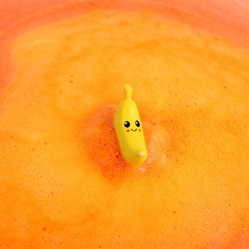 Brinquedo banana amarelo sorridente na espuma laranja da banheira