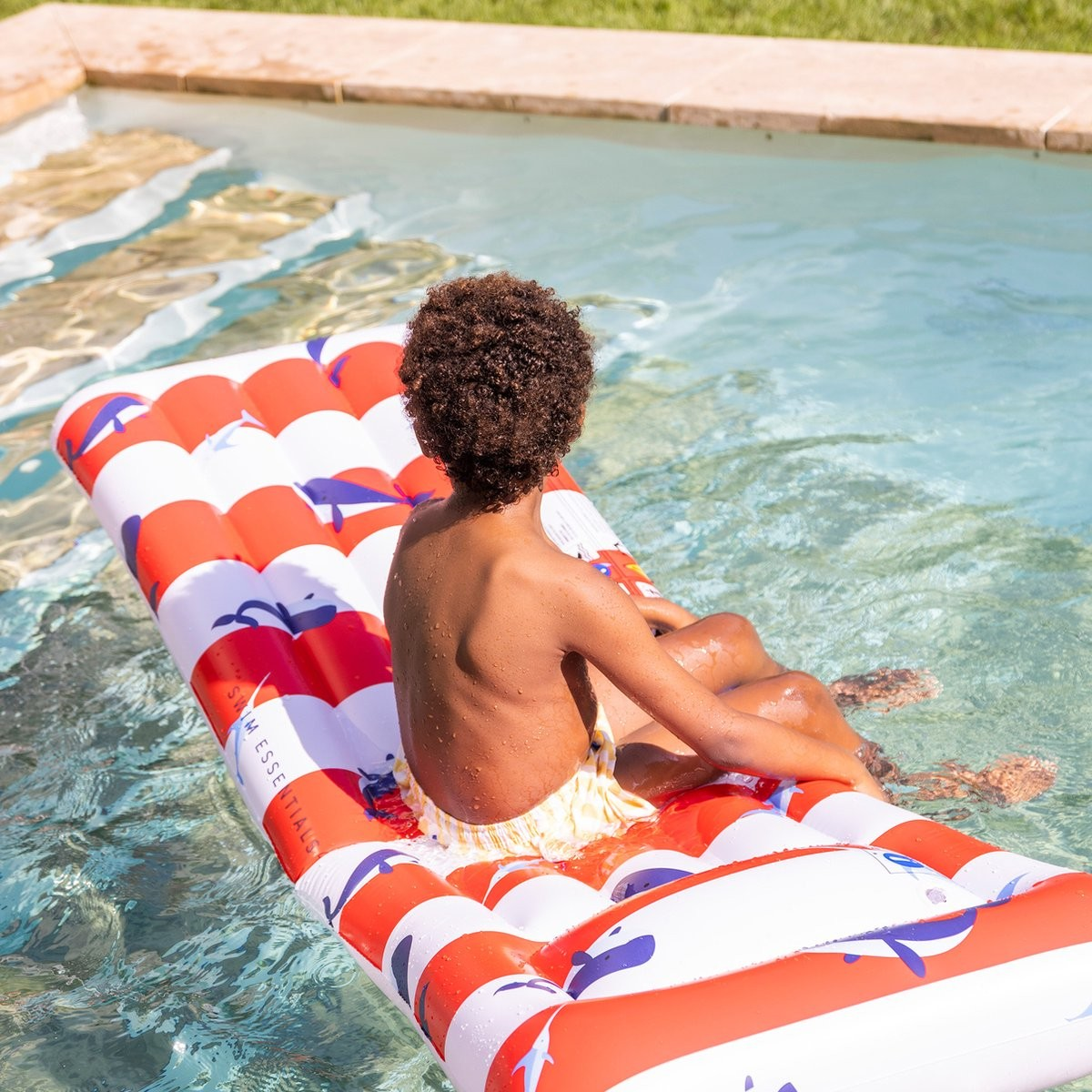 Colchão insuflável para piscina listrado vermelho e branco com detalhes azuis na água