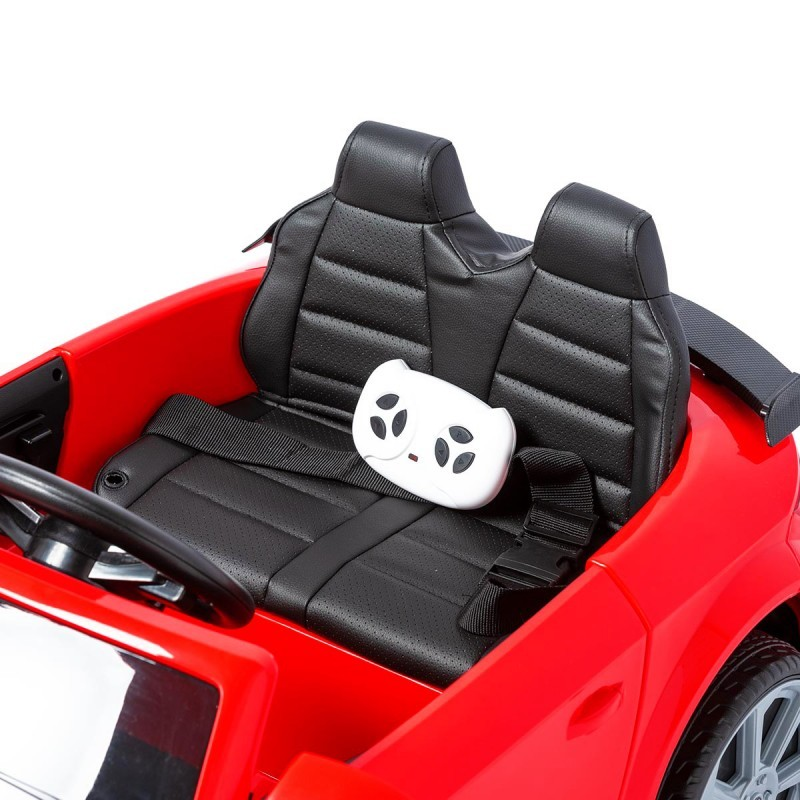 Carro elétrico de brinquedo vermelho com bancos pretos e comando remoto branco