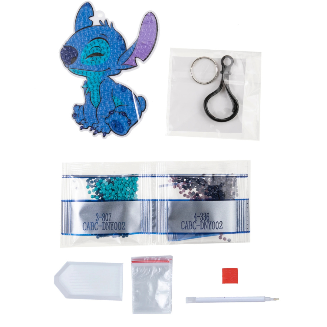 Kit de artesanato com a figura azul de um personagem, contas coloridas, suporte, saco, caneta e anel