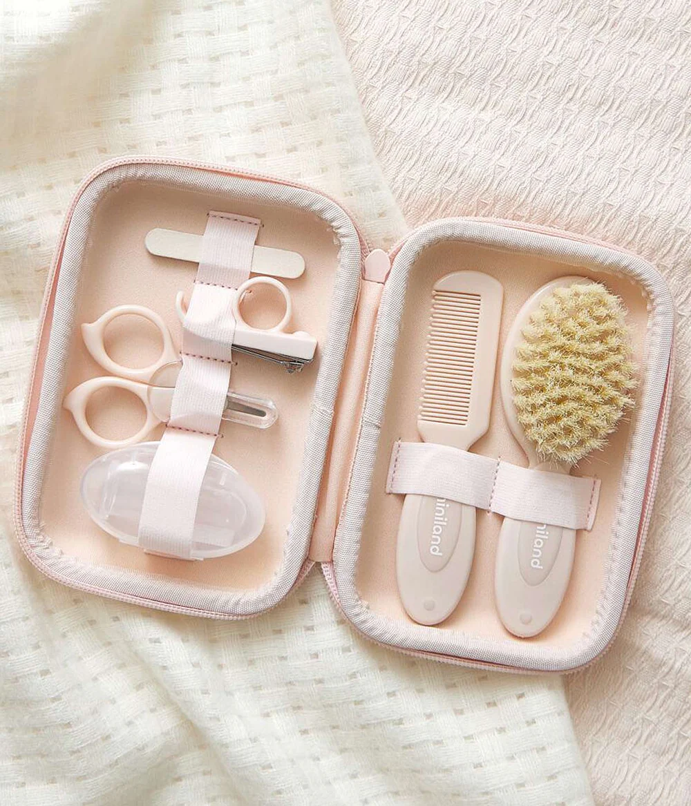 Conjunto de cuidados para bebé com escova, pente, tesoura, corta-unhas e lima dentro de estojo bege