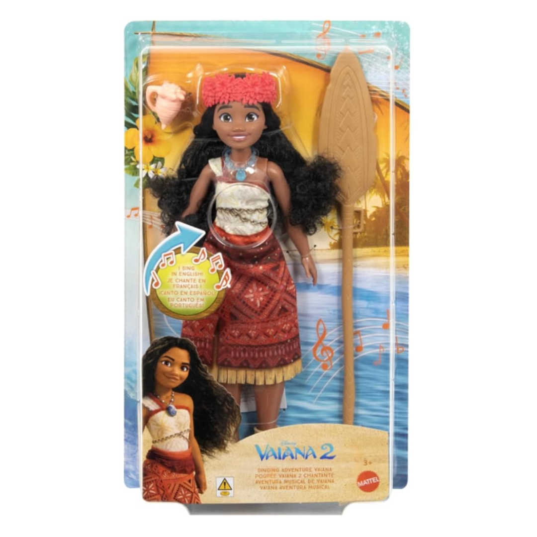 Boneca Vaiana 2 em packaging com remo e concha, com texto multilingue de três anos