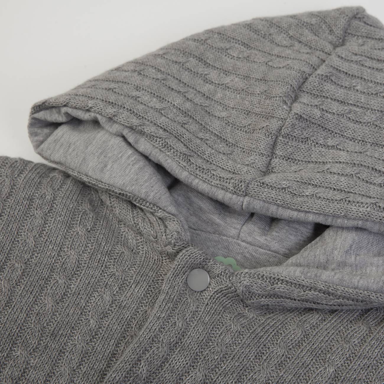 Casaco cinzento com capuz em tecido tricotado com padrão de trança e botões de pressão