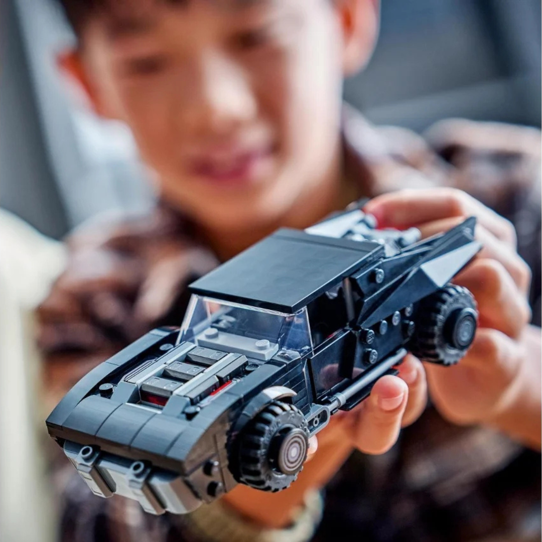Carrinha desportiva preta de blocos LEGO nas mãos de uma criança