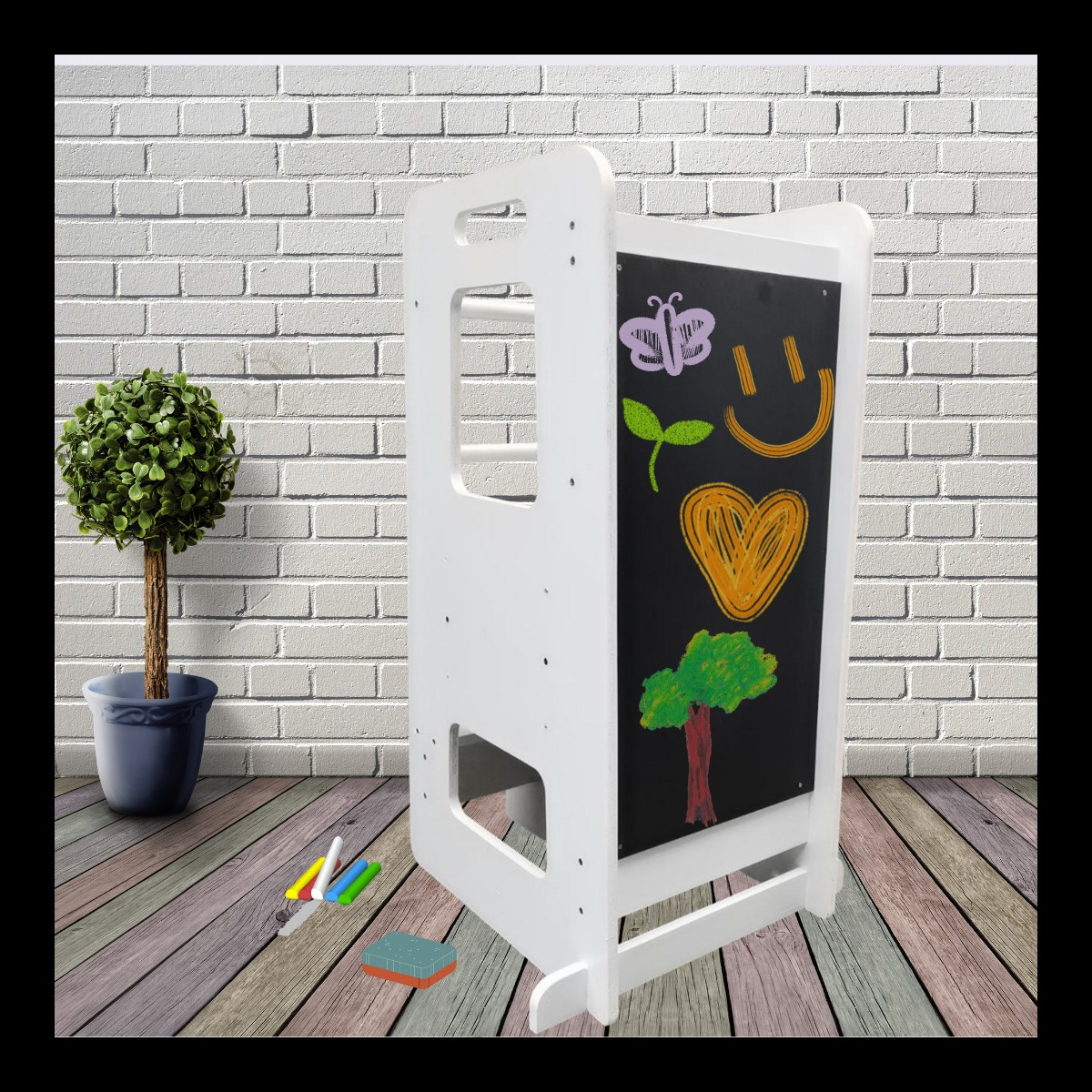 Quadro branco e negro com desenhos coloridos e planta em vaso ao lado