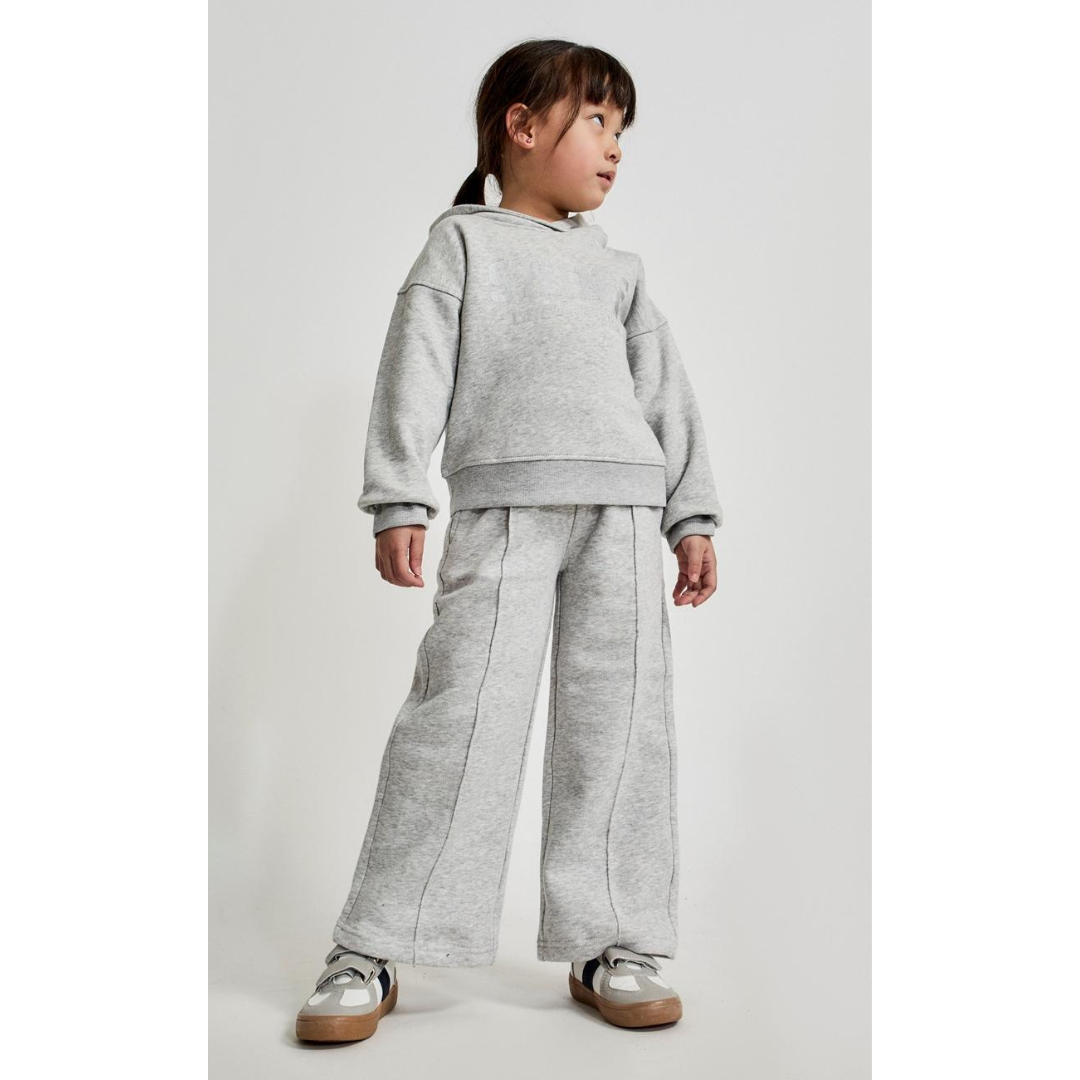 Menina com conjunto cinza claro de moletom e ténis