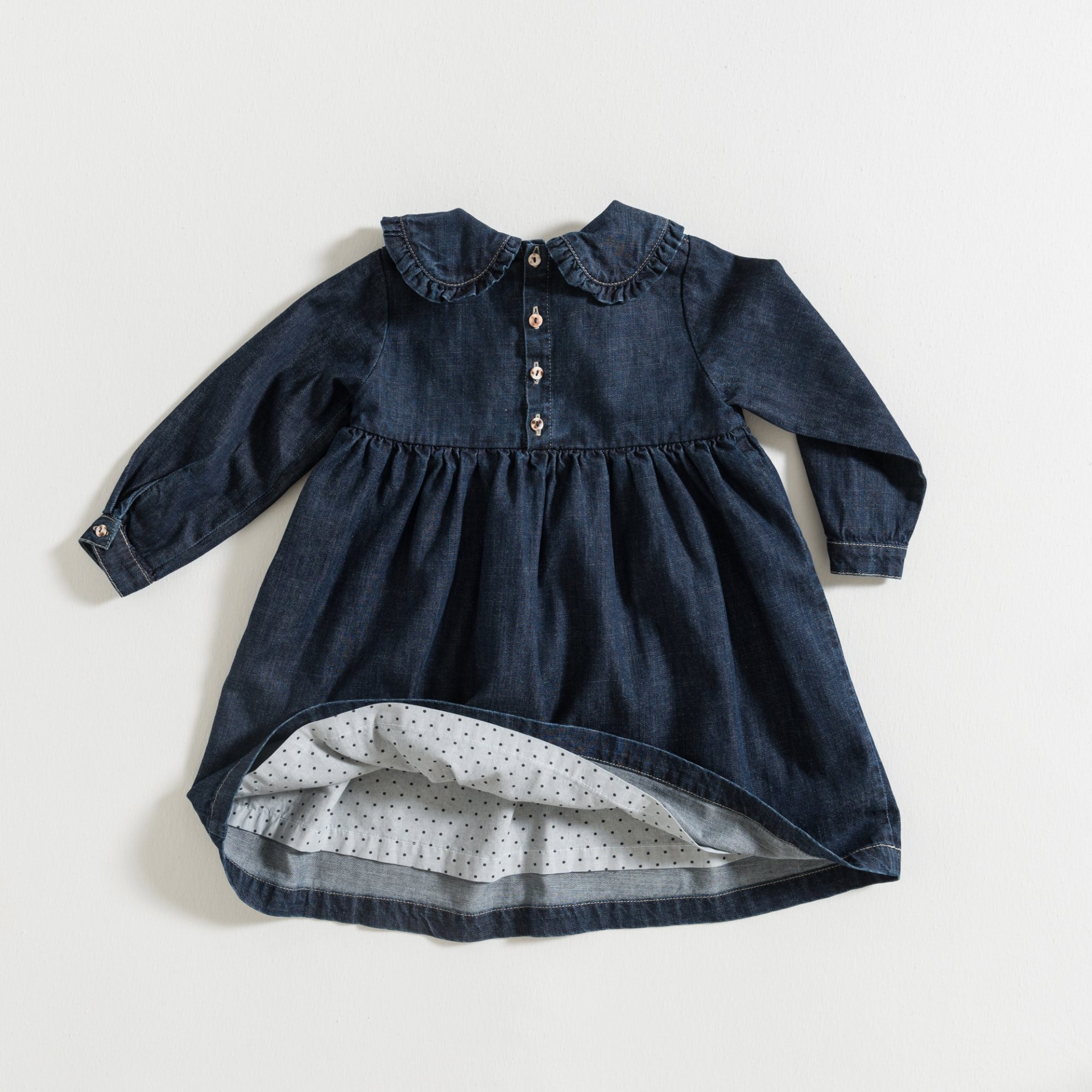Vestido infantil de denim azul escuro com gola e botões, forro de pontos.