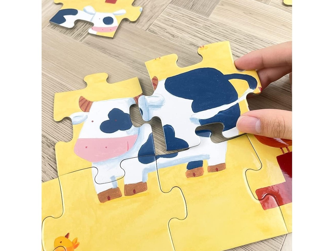 Peça de puzzle de vaca azul e branca em fundo amarelo em superfície de madeira