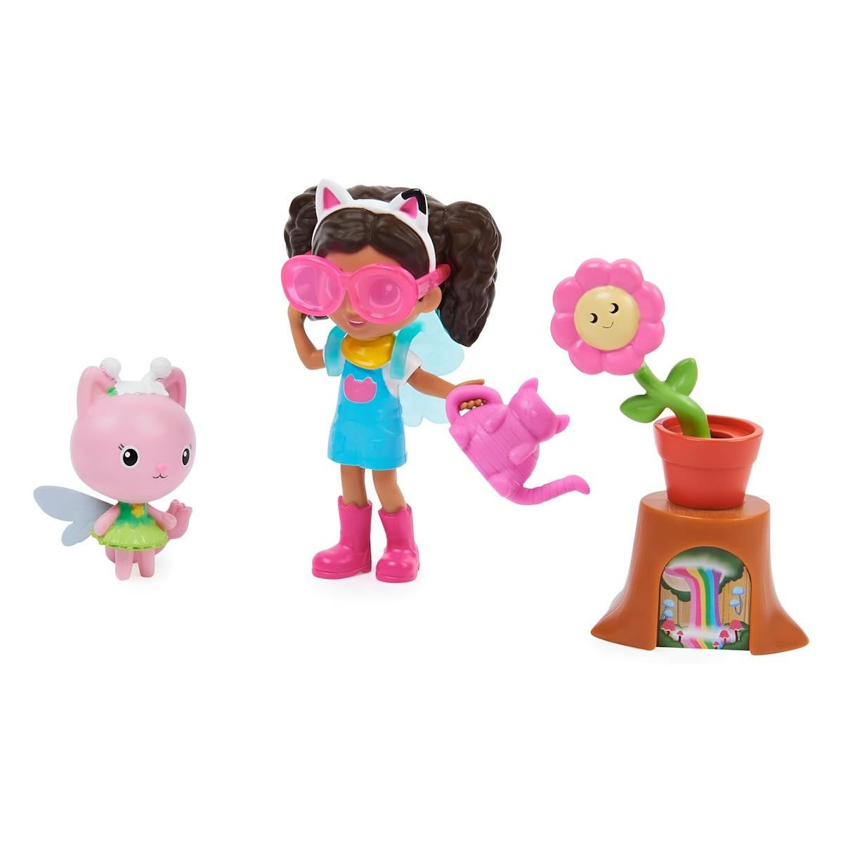 Conjunto de boneca, figura rosa de fada e flor sorridente em vaso sobre tronco.