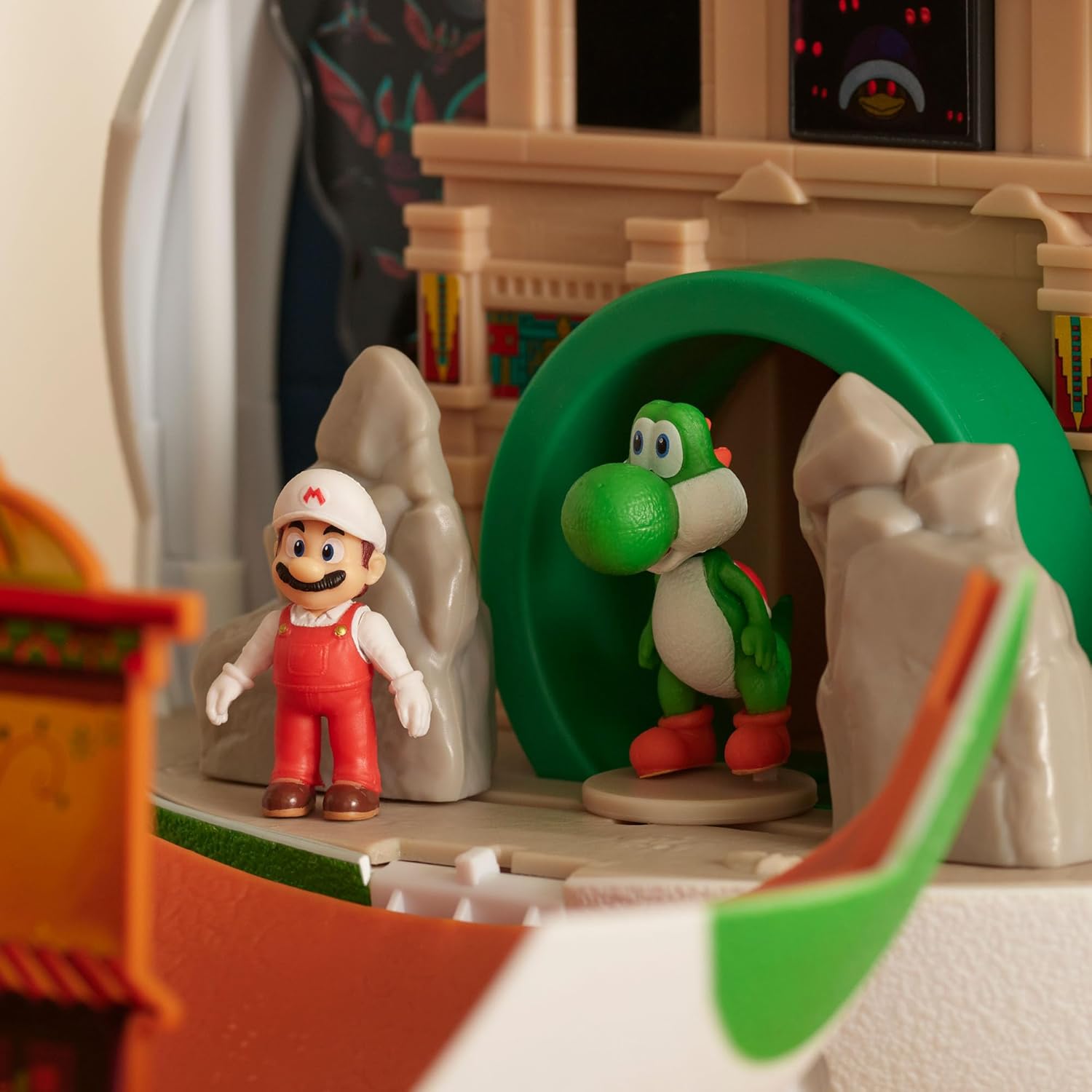 Figuras de brinquedo de Mario e Yoshi num cenário de brinquedo com pedras artificiais.