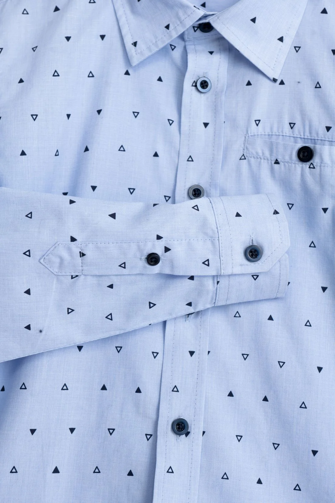 Camisa azul clara com padrão de triângulos pretos e botões pretos