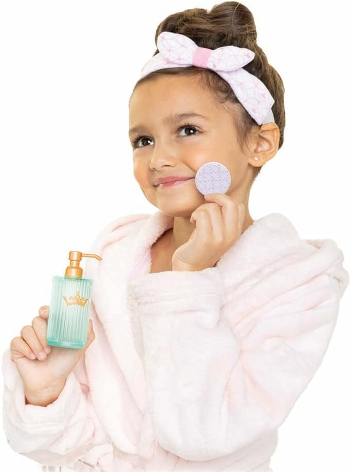 Menina segurando dispenser e disco de algodão com roupão de banho e banda para cabelo