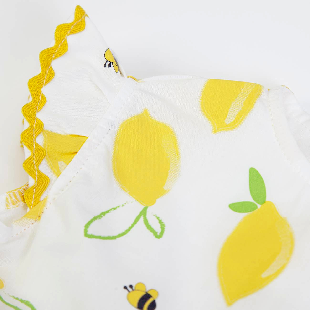 Pano branco com estampa de limões amarelos e abelhas com borda ondulada amarela