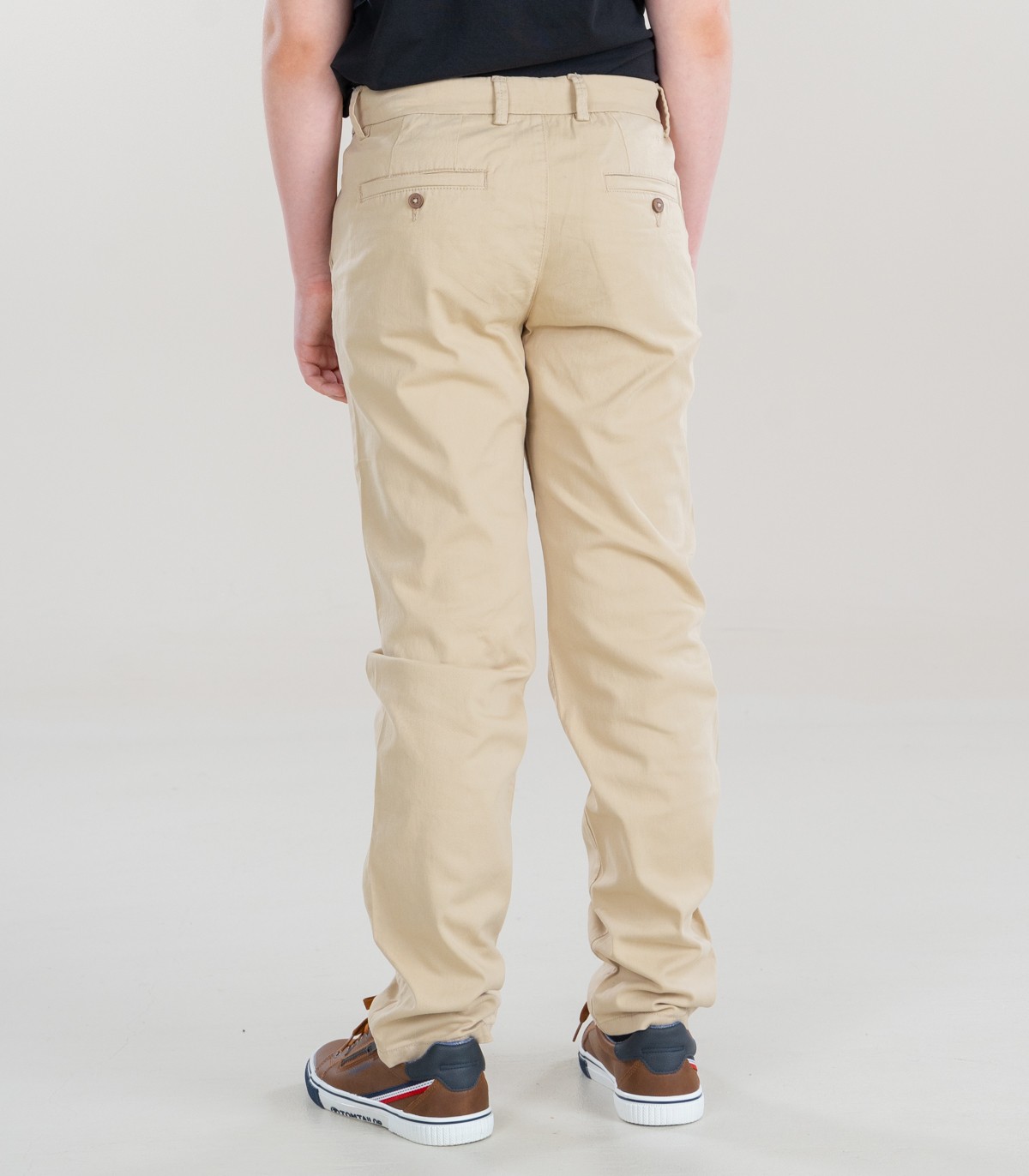 Calças bege com bolsos e sapatilhas castanhas vista de trás