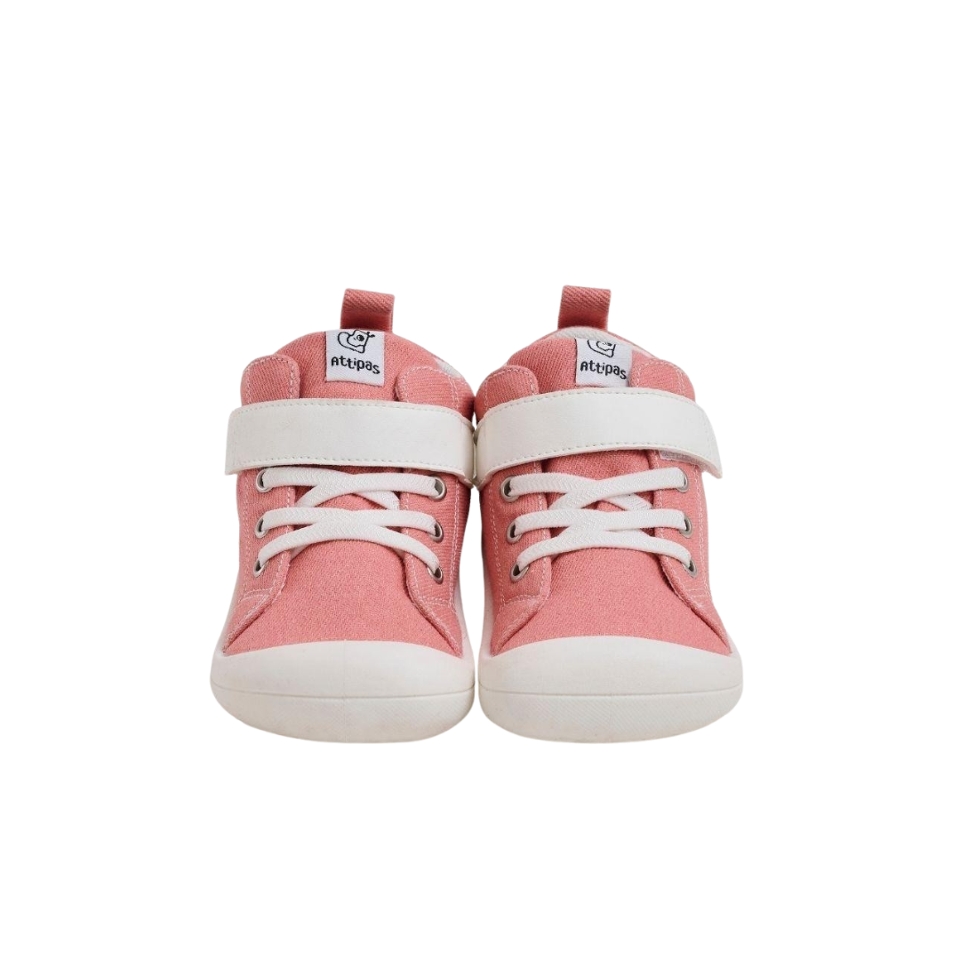Sapatilhas infantis cor de rosa com sola e tira branca, cadarços brancos e etiqueta 'atipas'