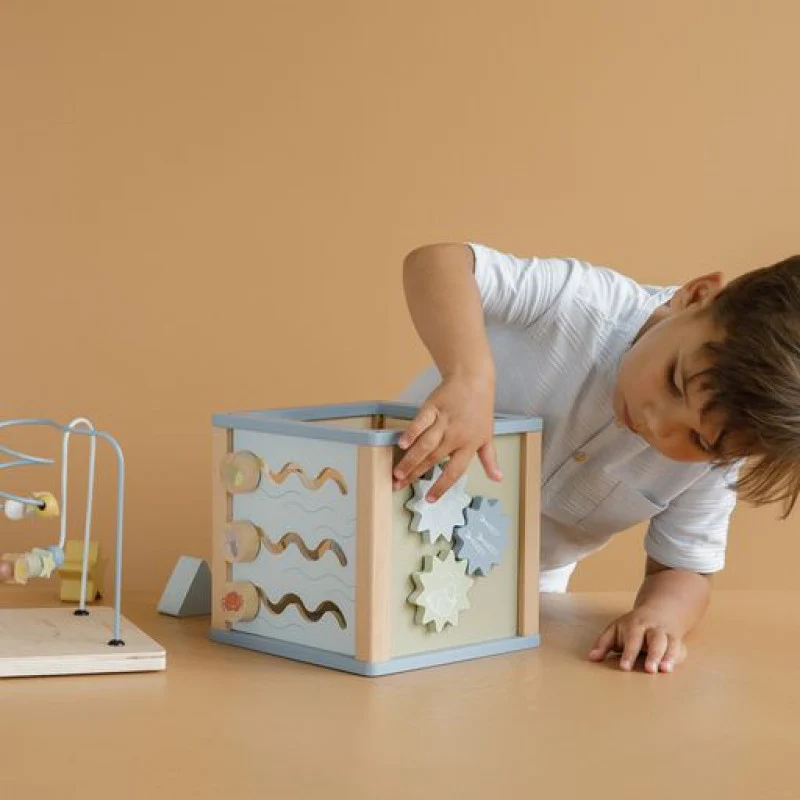 Criança a brincar com brinquedo educativo de madeira com peças giratórias e percursos moldados