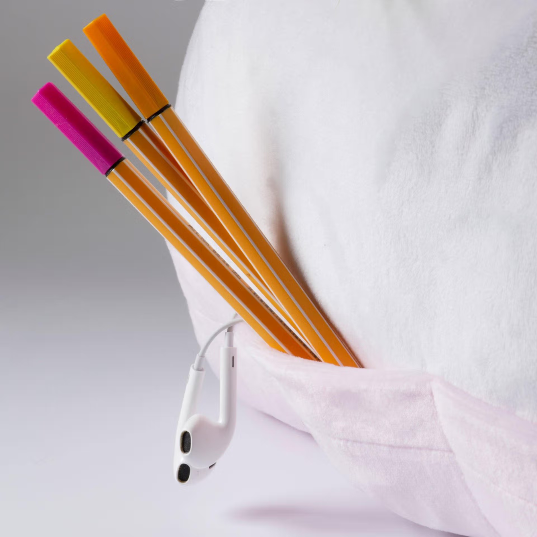 Lápis coloridos e auscultadores pendurados em bolso de almofada branca