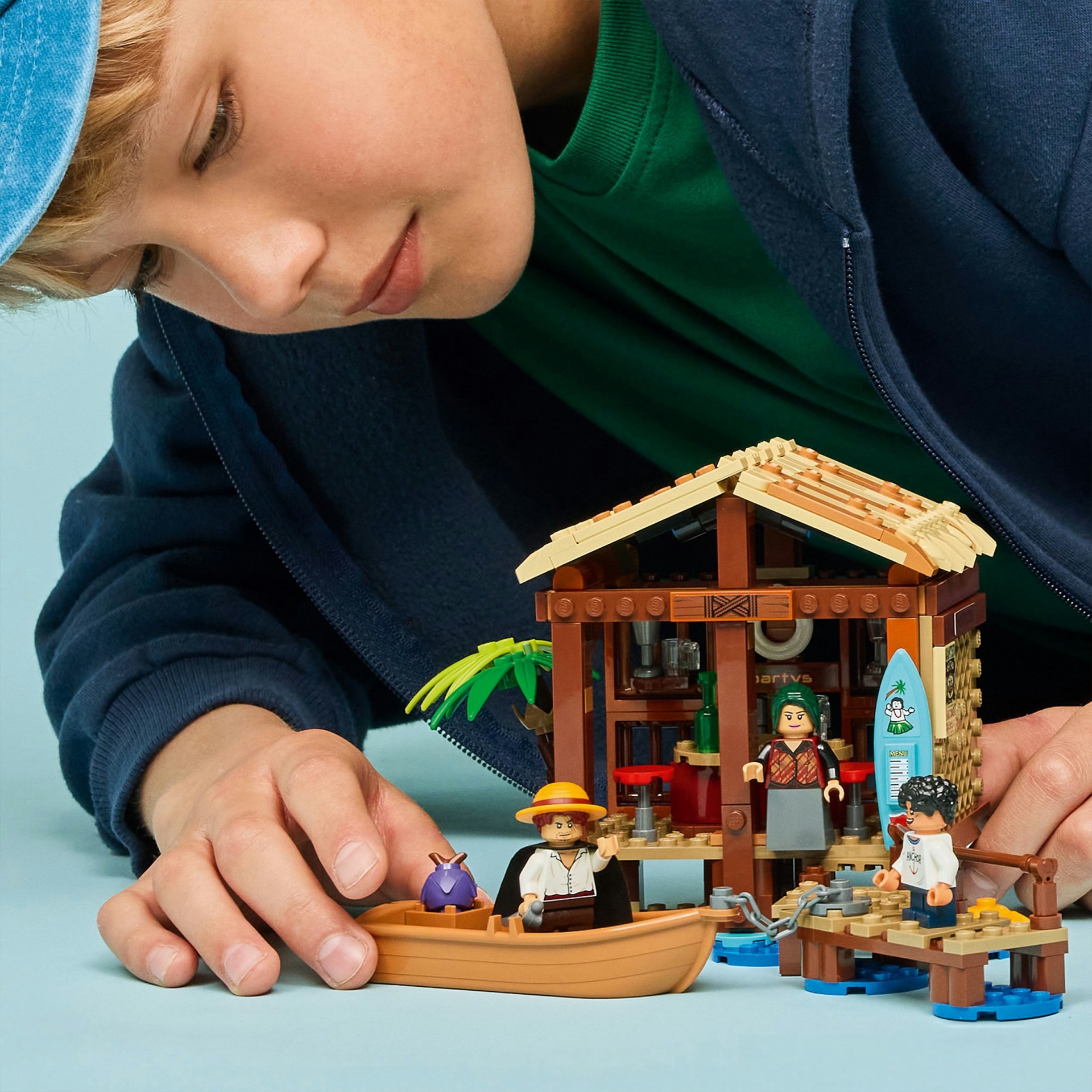 Criança a brincar com conjunto de blocos de construção de cabana e figuras coloridas