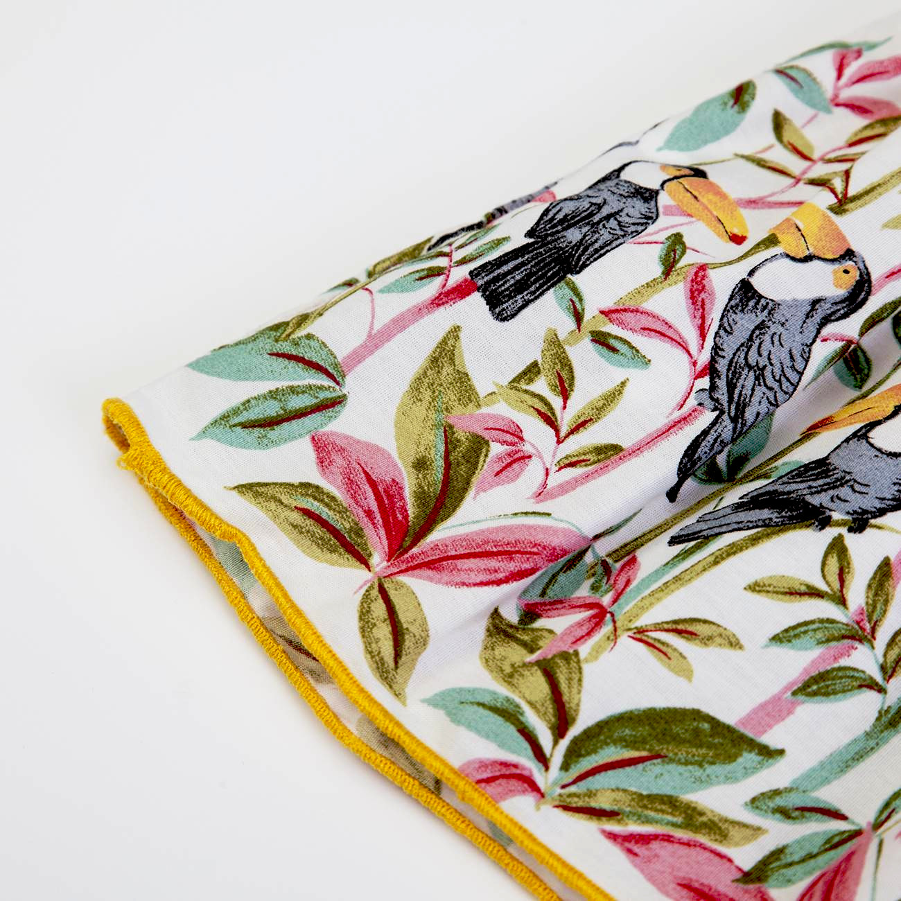 tecido com padrão de folhas coloridas e pássaros com costura amarela