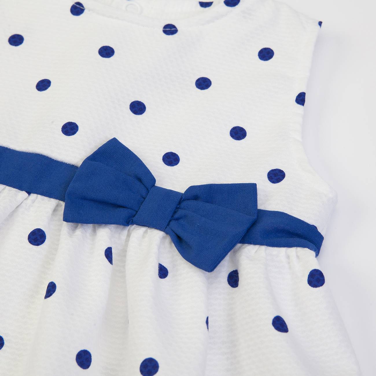 Vestido infantil branco com bolinhas azuis e laço azul na cintura