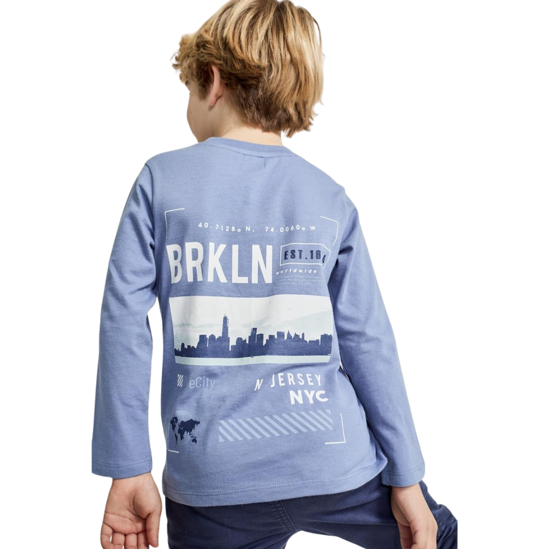 Criança com camisola azul de manga comprida vista de costas, com estampa de texto e skyline nas costas