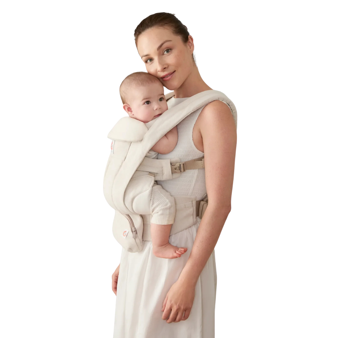 Mulher com porta-bebés ergonómico bege claro carregando bebé.