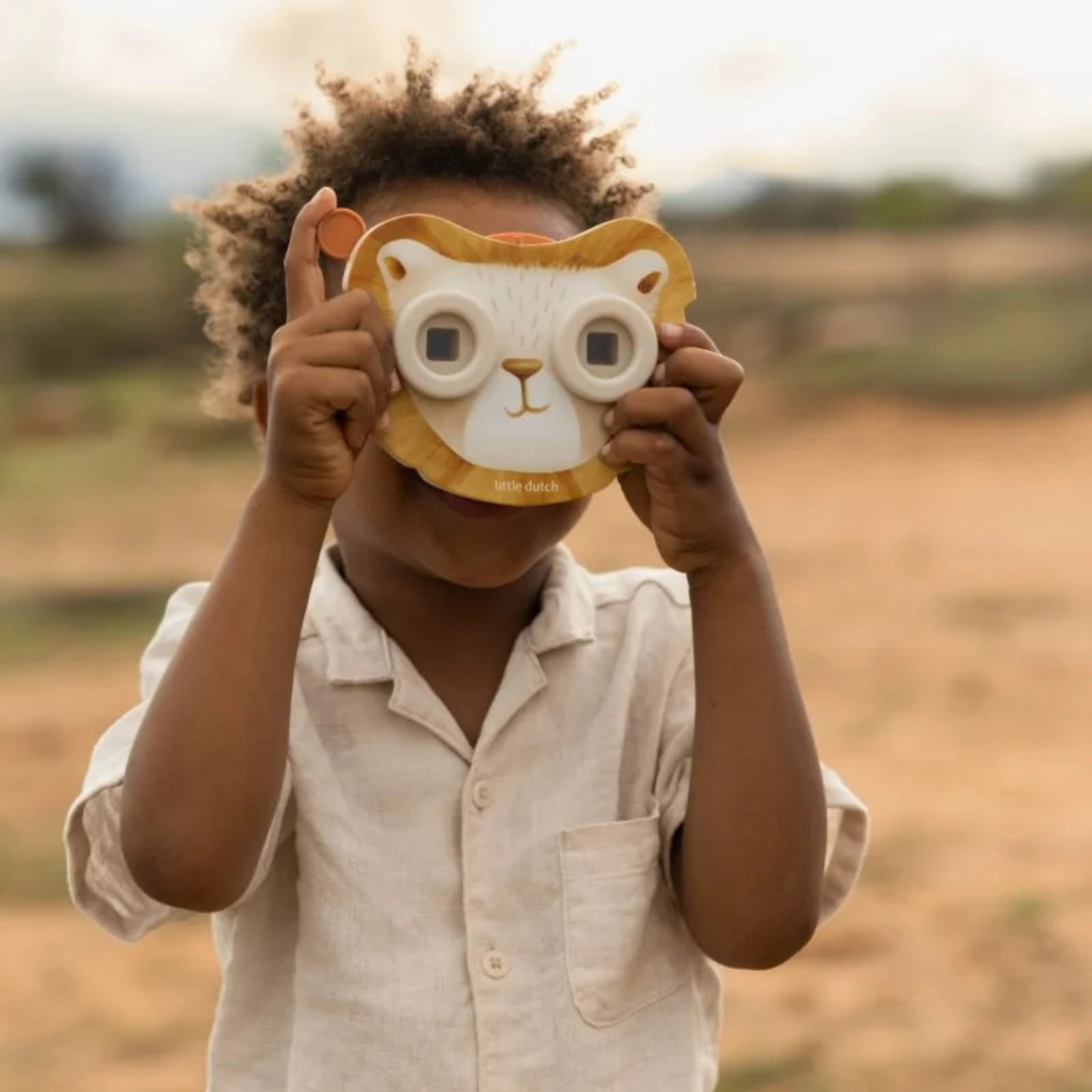 Criança com brinquedo binocular em forma de rosto de leão