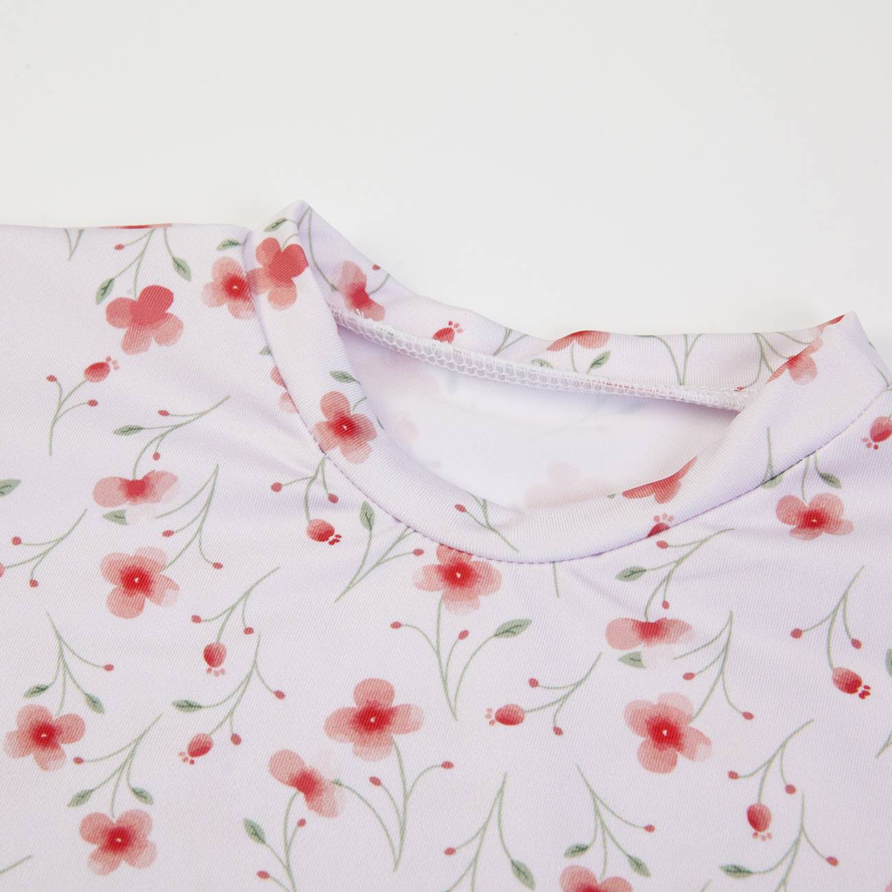 T-shirt branca com padrão floral vermelho e verde e gola redonda