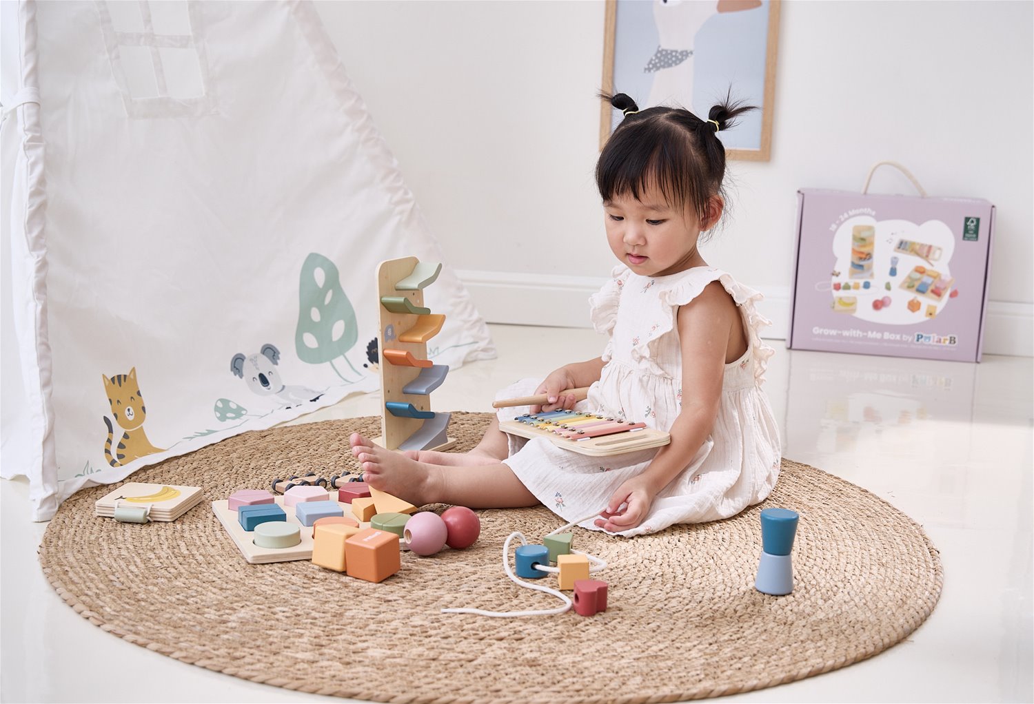 Criança a brincar com brinquedos de madeira coloridos num tapete redondo de ráfia