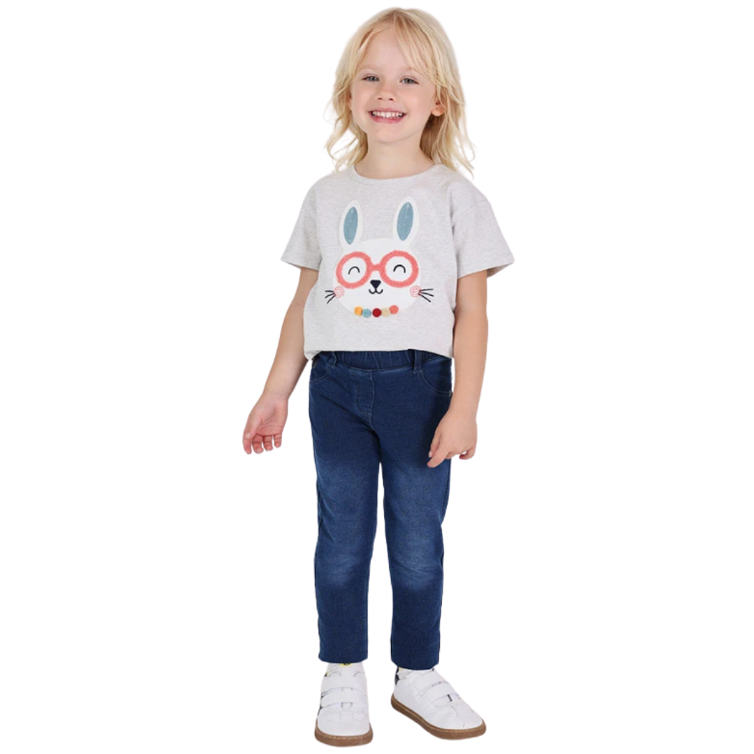 Criança com camisola com coelho e calças de ganga em fundo branco